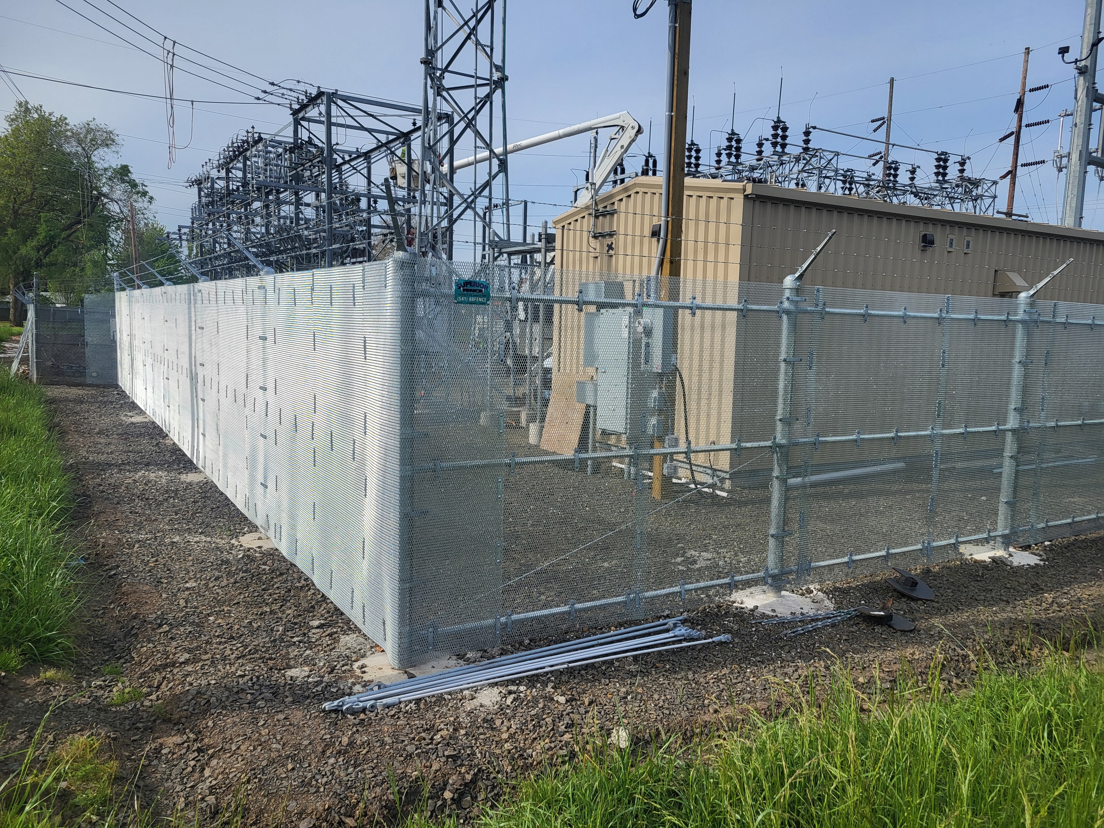 Heavy-duty chain link fence with privacy screening enclosing a utility substation — Southern Oregon