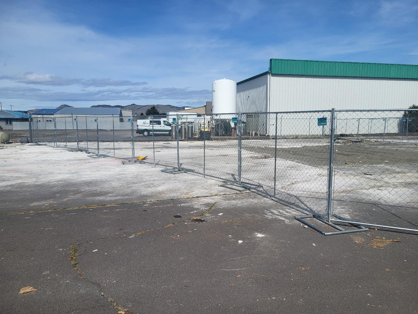 Temporary chain link fence panels at an industrial facility in winter