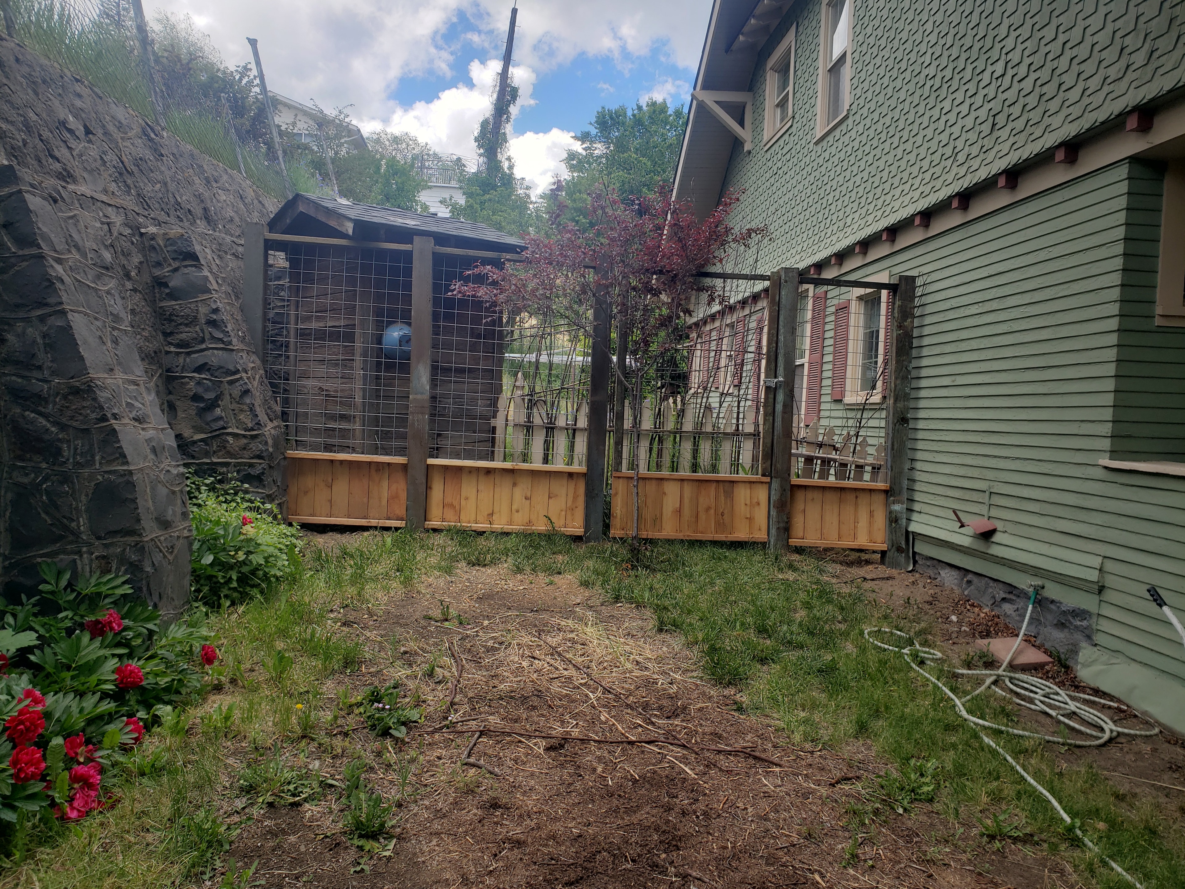 Dog-eared wood privacy fence installed next to a log home with Superior Fence signage